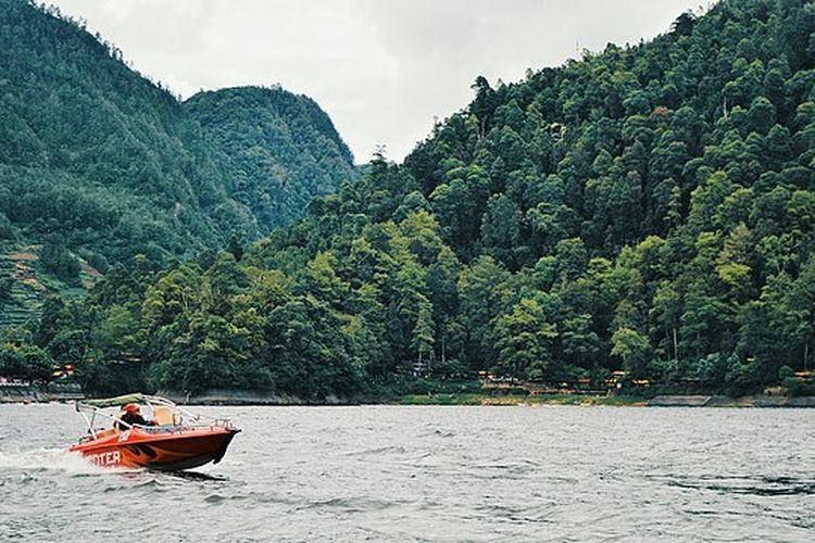 Waduk Penjalin di Brebes adalah destinasi wisata yang menawarkan keindahan alam yang menakjubkan serta berbagai fasilitas yang menarik bagi pengunjung. Terletak di antara pegunungan dan persawahan, waduk ini tidak hanya berfungsi sebagai sumber air untuk irigasi, tetapi juga menjadi tempat rekreasi yang populer bagi warga lokal dan wisatawan. Keberadaan Waduk Penjalin yang dikelilingi oleh panorama alam yang memukau menjadikannya tempat yang ideal untuk melepaskan penat dan menikmati ketenangan. Dalam artikel ini, kita akan membahas secara mendalam mengenai daya tarik yang ditawarkan oleh Waduk Penjalin, harga tiket masuk, serta rute yang dapat diambil untuk mengunjungi tempat ini. 1. Daya Tarik Waduk Penjalin Waduk Penjalin tidak hanya dikenal sebagai sumber air yang penting, tetapi juga sebagai lokasi wisata yang menawarkan berbagai daya tarik. Salah satu daya tarik utama dari Waduk Penjalin adalah pemandangan alamnya yang menakjubkan. Dikelilingi oleh pegunungan hijau dan sawah yang luas, pengunjung dapat menikmati keindahan panorama yang beragam. Di pagi hari, kabut tipis sering menyelimuti area waduk, menciptakan suasana yang magis dan menenangkan. Selain itu, Waduk Penjalin juga menawarkan berbagai aktivitas rekreasi yang bisa dinikmati pengunjung. Salah satunya adalah berkendara sepeda mengelilingi area waduk. Pengunjung dapat menyewa sepeda dan menjelajahi jalan setapak yang berkelok di sekitar waduk. Aktivitas ini tidak hanya menyenangkan tetapi juga memberikan kesempatan untuk menikmati suasana alam yang segar dan menyehatkan. Bagi pecinta fotografi, Waduk Penjalin juga menjadi lokasi yang ideal untuk mengabadikan momen indah. Dengan latar belakang pegunungan dan air waduk yang jernih, pengunjung dapat mengambil foto-foto yang menakjubkan. Saat matahari terbenam, keindahan waduk semakin mempesona dengan warna-warni langit yang memukau. Selain keindahan alamnya, Waduk Penjalin juga dilengkapi dengan berbagai fasilitas pendukung. Terdapat area parkir yang luas, warung makanan, maupun gazebo tempat bersantai. Pengunjung dapat menikmati makanan khas Brebes sambil menikmati pemandangan waduk. Hal inilah yang menjadikan Waduk Penjalin sebagai tempat yang ramah bagi keluarga dan kelompok. Kegiatan lain yang dapat dilakukan adalah memancing. Pengunjung yang suka memancing bisa membawa peralatan mereka sendiri atau menyewa di sekitar waduk. Ikan-ikan yang terdapat di waduk memberikan tantangan tersendiri bagi para pemancing. Dengan segala daya tarik yang dimiliki, Waduk Penjalin mampu menarik perhatian wisatawan dari berbagai kalangan. Baik itu keluarga yang ingin berlibur, pasangan yang mencari momen romantis, maupun individu yang hanya ingin menikmati ketenangan alam. 2. Harga Tiket Masuk Waduk Penjalin Bagi siapa pun yang ingin mengunjungi Waduk Penjalin, informasi mengenai harga tiket masuk menjadi hal yang penting untuk diketahui. Salah satu aspek yang menarik dari waduk ini adalah harga tiketnya yang terjangkau, sehingga dapat diakses oleh semua kalangan. Sebagai tujuan wisata yang ramah anggaran, Waduk Penjalin menawarkan tiket masuk dengan harga yang bervariasi berdasarkan hari dan fasilitas yang digunakan. Harga tiket masuk biasanya berkisar antara Rp 5.000 hingga Rp 10.000 per orang. Harganya dapat berbeda di akhir pekan atau pada hari libur tertentu. Pada hari-hari tersebut, wisatawan mungkin akan menemukan biaya tambahan untuk parkir kendaraan atau sewa fasilitas. Namun, harga tersebut masih tergolong sangat wajar mengingat keindahan dan fasilitas yang ditawarkan oleh waduk ini. Selain tiket masuk, pengunjung juga perlu memperhitungkan biaya tambahan untuk aktivitas lain yang ingin dilakukan selama berada di Waduk Penjalin. Seperti yang telah disebutkan sebelumnya, pengunjung dapat menyewa sepeda untuk berkeliling, yang biasanya dikenakan biaya sewa sekitar Rp 20.000 per jam. Begitu pula, jika Anda ingin memancing di waduk, biasanya akan ada biaya sewa alat pancing yang ditawarkan oleh pedagang lokal. Bagi pengunjung yang ingin menikmati kuliner khas Brebes, terdapat banyak warung yang menawarkan berbagai hidangan dengan harga yang bervariasi. Anda bisa mencicipi makanan lokal, seperti tahu dan tempe Brebes, sambil menikmati suasana alami yang damai. Harga makanan di warung-warung tersebut sangat terjangkau, berkisar antara Rp 15.000 hingga Rp 50.000 tergantung menu yang dipilih. Dengan kombinasi harga tiket yang terjangkau dan beragam aktivitas menarik, Waduk Penjalin menawarkan nilai lebih bagi pengunjung yang ingin merasakan pengalaman wisata alam. Alhasil, Waduk Penjalin menjadi destinasi yang sangat layak untuk dikunjungi tanpa perlu merogoh kocek terlalu dalam. 3. Rute Menuju Waduk Penjalin Untuk mencapai Waduk Penjalin, pengunjung harus mengetahui rute yang tepat agar perjalanan menjadi lebih lancar. Waduk ini terletak di wilayah Brebes, tepatnya di Desa Penjalin, Kecamatan Brebes. Lokasinya cukup strategis dan dapat diakses dari berbagai arah, baik menggunakan kendaraan pribadi maupun angkutan umum. Jika Anda berangkat dari pusat kota Brebes, perjalanan menuju Waduk Penjalin memakan waktu sekitar 30 menit dengan kendaraan pribadi. Anda bisa menuju ke arah Jalan Jend. Sudirman, lalu belok ke Jalan Raya Penjalin. Ikuti petunjuk arah hingga tiba di lokasi waduk. Sepanjang perjalanan, Anda akan disuguhi pemandangan indah ala pedesaan yang menenangkan. Bagi pengunjung yang menggunakan angkutan umum, terdapat berbagai pilihan transportasi yang dapat digunakan. Anda bisa naik angkutan umum menuju terminal Brebes, kemudian melanjutkan dengan ojek atau mobil rental menuju Waduk Penjalin. Pastikan untuk menanyakan kepada pengemudi mengenai lokasi yang dituju agar tidak salah arah. Bagi wisatawan yang datang dari luar kota, Anda bisa menggunakan transportasi kereta api atau bus menuju Brebes. Setelah tiba di stasiun atau terminal, Anda bisa melanjutkan perjalanan dengan angkutan umum atau menyewa kendaraan. Jika Anda menggunakan kendaraan pribadi dari kota-kota besar seperti Semarang atau Cirebon, Anda bisa mengikuti rute jalan tol yang menghubungkan antar kota. Selama perjalanan, Anda juga akan menemukan berbagai tempat menarik lainnya yang dapat dijadikan sebagai alternatif lokasi wisata. Oleh karena itu, jika waktu memungkinkan, Anda dapat merencanakan kunjungan ke beberapa tempat sekaligus untuk mendapatkan pengalaman wisata yang lebih kaya. Dengan mengetahui rute yang tepat dan mempersiapkan segala sesuatunya, kunjungan Anda ke Waduk Penjalin akan menjadi lebih nyaman dan menyenangkan. Pastikan untuk mengecek kondisi cuaca sebelum berangkat agar perjalanan tidak terganggu oleh hujan atau cuaca buruk lainnya. 4. Aktivitas Menarik di Waduk Penjalin Waduk Penjalin tidak hanya menawarkan keindahan alam, tetapi juga beragam aktivitas menarik yang bisa dilakukan pengunjung. Salah satu aktivitas yang paling populer adalah berkendara sepeda. Area sekitar waduk memiliki jalur yang aman dan nyaman untuk bersepeda. Pengunjung dapat menyewa sepeda dengan harga terjangkau dan menjelajahi keindahan alam sambil berolahraga. Selain itu, memancing juga menjadi salah satu aktivitas yang banyak diminati oleh pengunjung. Waduk Penjalin merupakan habitat bagi berbagai jenis ikan, sehingga menjadi tantangan tersendiri bagi para pemancing. Anda bisa membawa peralatan memancing sendiri atau menyewa peralatan yang disediakan oleh pedagang di sekitar waduk. Ini adalah kesempatan yang baik untuk bersantai dan menikmati waktu bersama keluarga atau teman-teman. Bagi pengunjung yang mencari ketenangan, duduk-duduk di gazebo sambil menikmati pemandangan waduk juga merupakan pilihan yang tepat. Gazebo-gazebo yang tersedia menyediakan tempat yang nyaman untuk bersantai dan menikmati suasana. Anda bisa membawa bekal dari rumah atau membeli makanan di warung yang ada di sekitar waduk. Pengunjung juga bisa melakukan piknik keluarga di area yang telah disediakan. Dengan membawa alas dan makanan, pengunjung dapat menikmati waktu berkualitas bersama orang terkasih. Pada hari-hari tertentu, Waduk Penjalin sering mengadakan acara atau festival lokal yang menampilkan seni dan budaya setempat, sehingga pengunjung dapat merasakan suasana yang lebih hidup. Keberadaan fasilitas umum, seperti toilet dan tempat sampah, juga memudahkan pengunjung untuk menjaga kebersihan. Dengan beragam aktivitas yang ditawarkan, Waduk Penjalin memberikan pengalaman yang menyenangkan bagi setiap pengunjung.